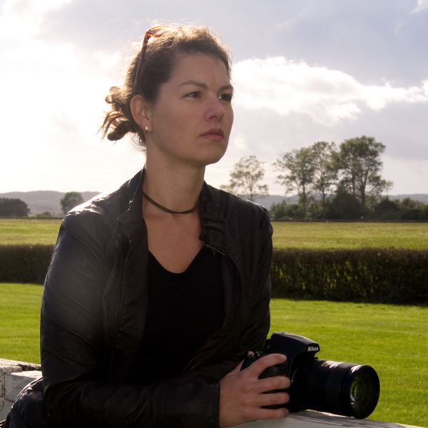 Portraitaufnahme von Anka Sandeck im Freien mit einer Fotokamera in der Hand
